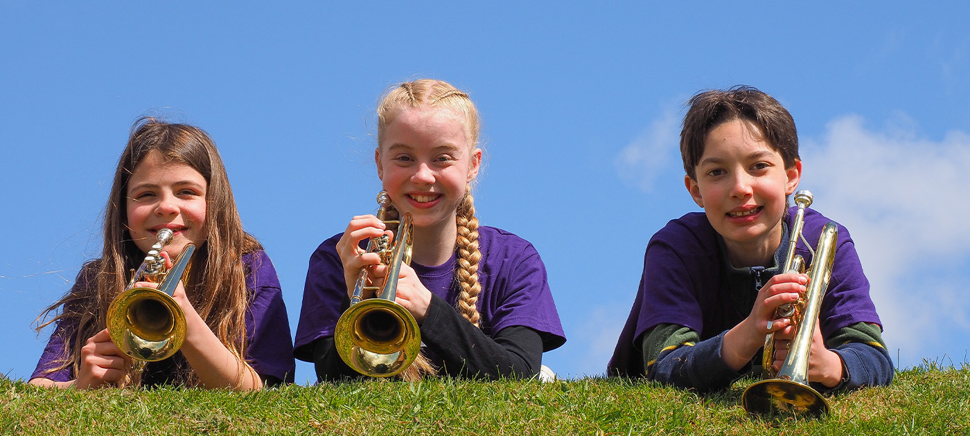 three girls with brass instruments