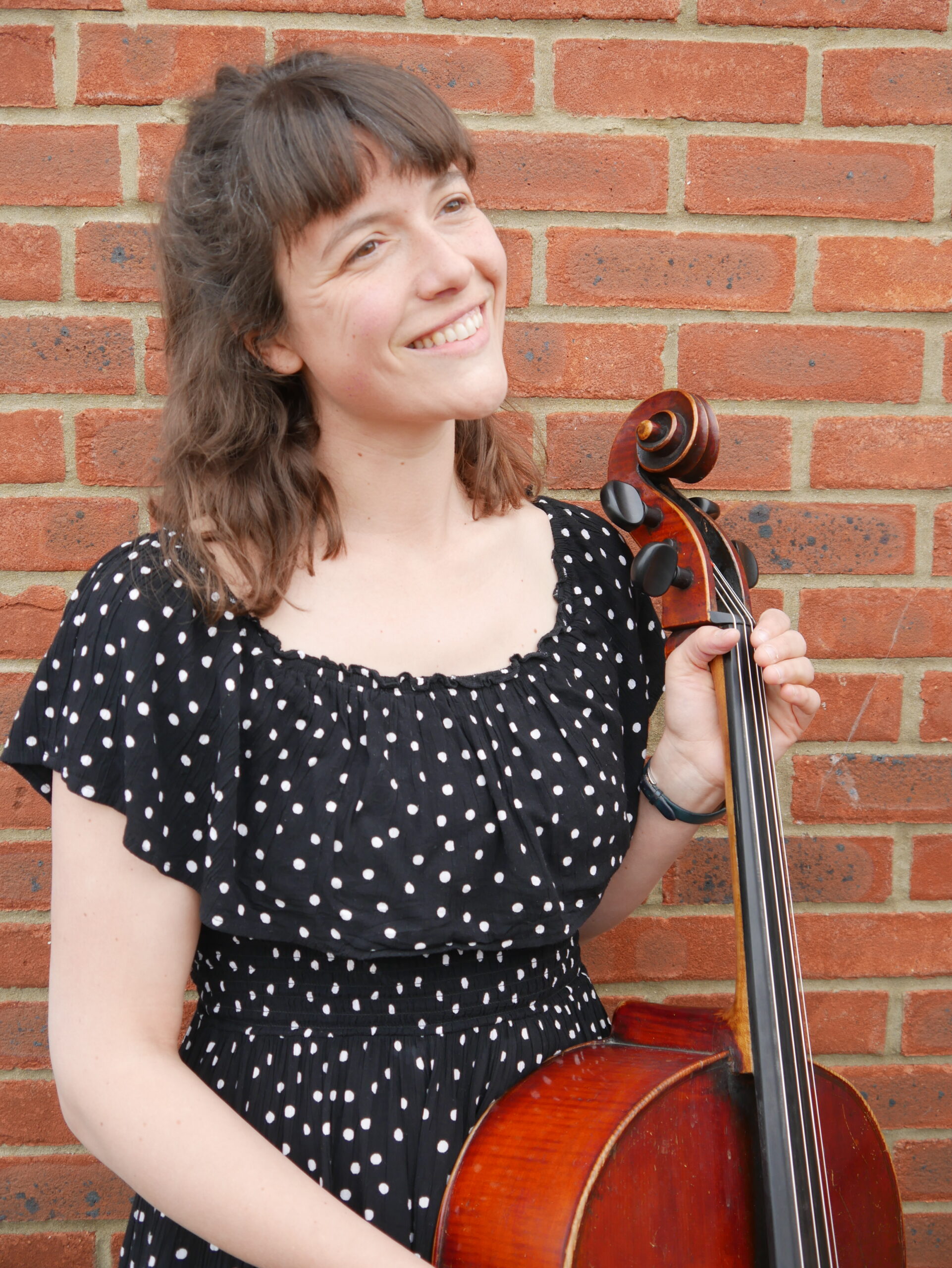 Diana holding a cello smiling