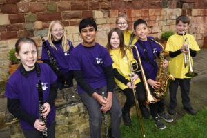 7 young musicians smiling holding instruments