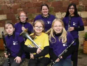 Group of 6 young musicians holding instruments smiling