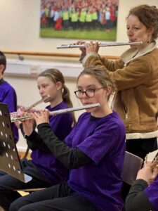 Two flautists with teacher behind
