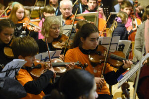 Group of teachers and students playing violins