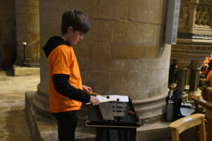 Boy playing percussion in abbey