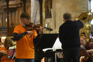 Violinist solo with conductor next door