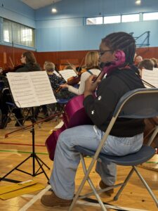 Young girl playing cello with sheet music in front
